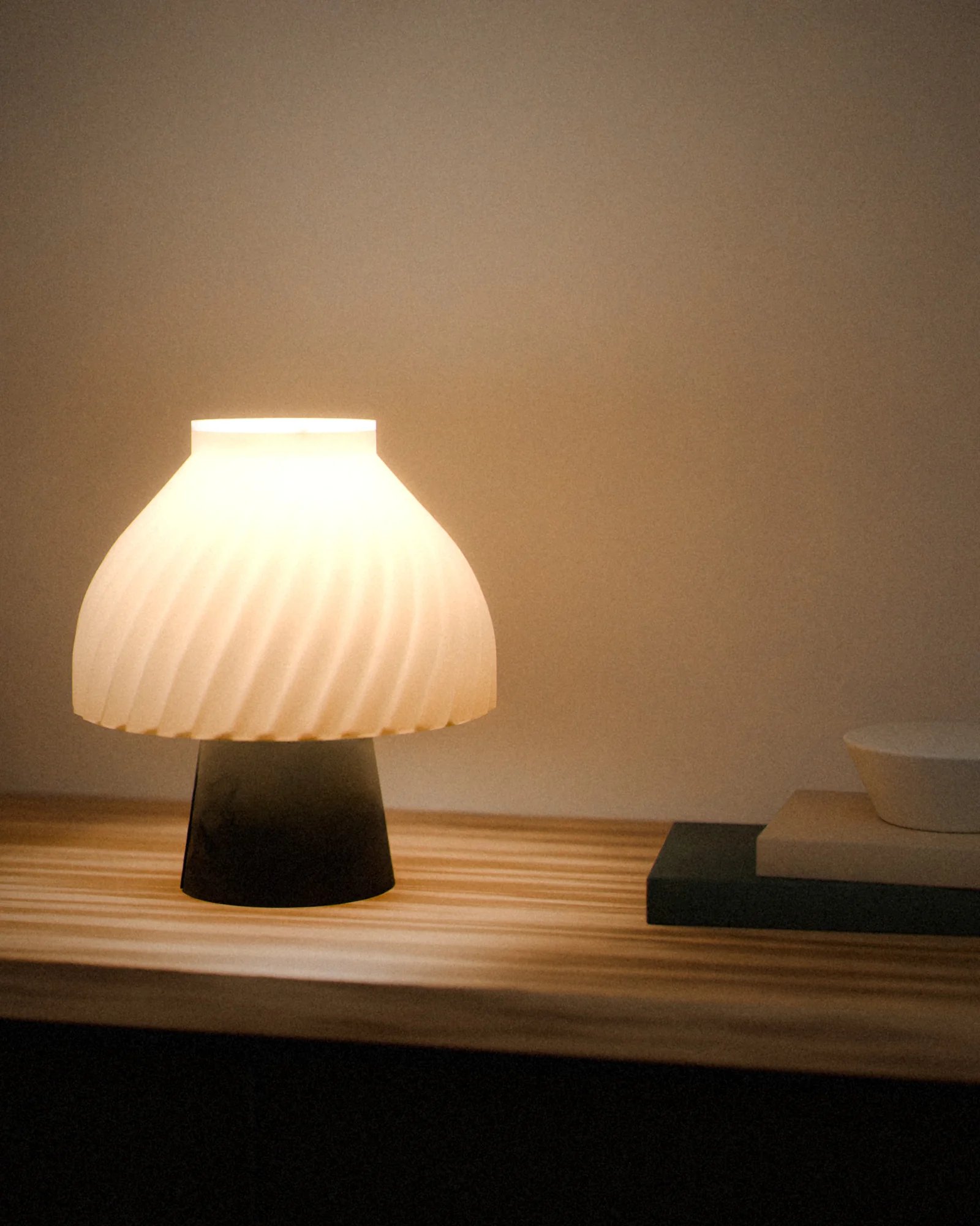 The same lamp lit, the light coming through its wall