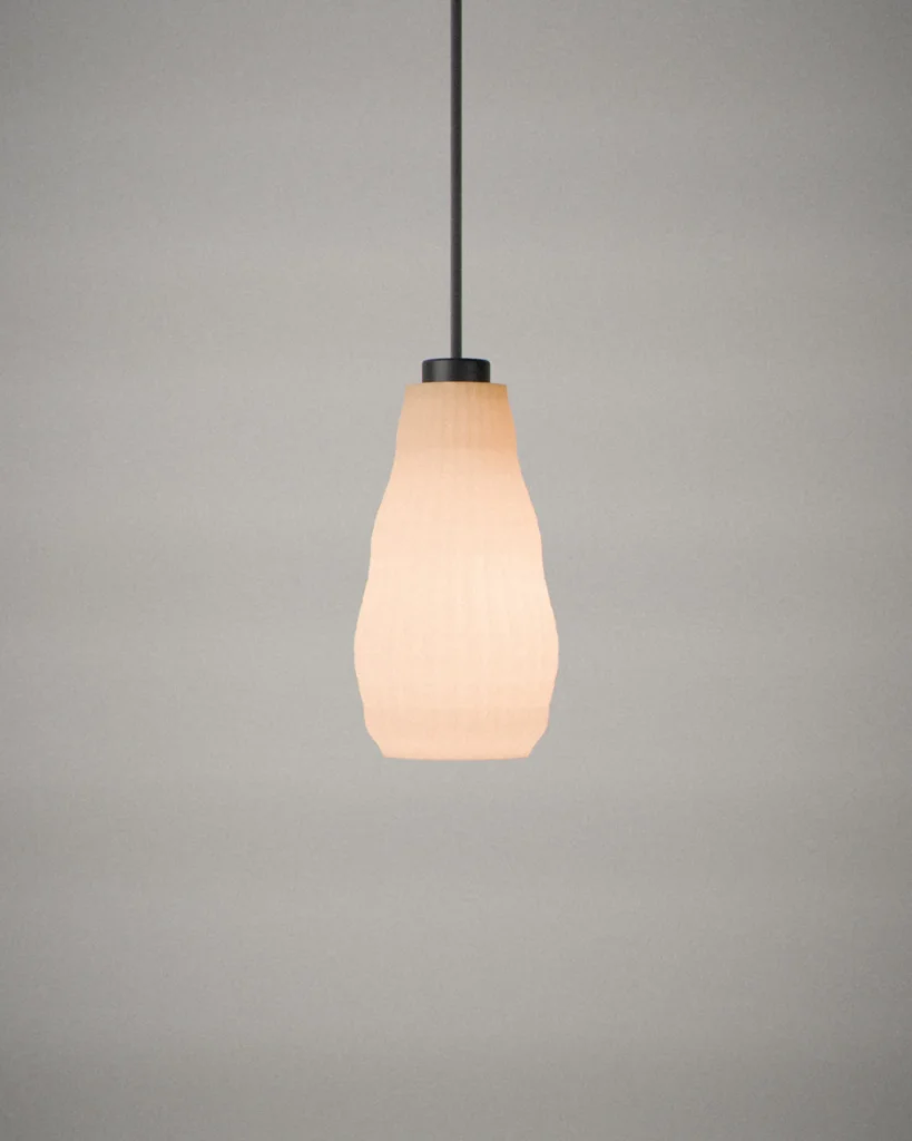 Pear, lit, on a pale grey wall